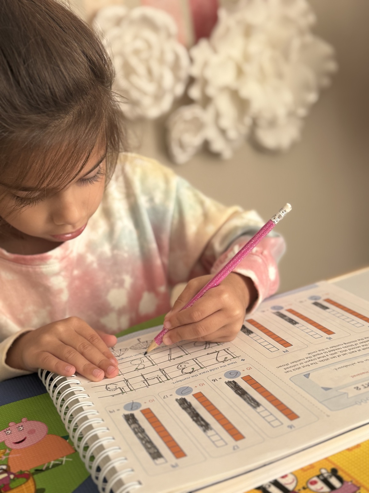 A young child practicing math during a homeschool lesson